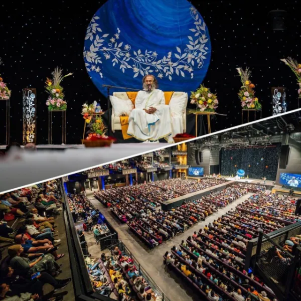 Gurudev Sri Sri Ravi Shankar on stage in front of a large arena audience